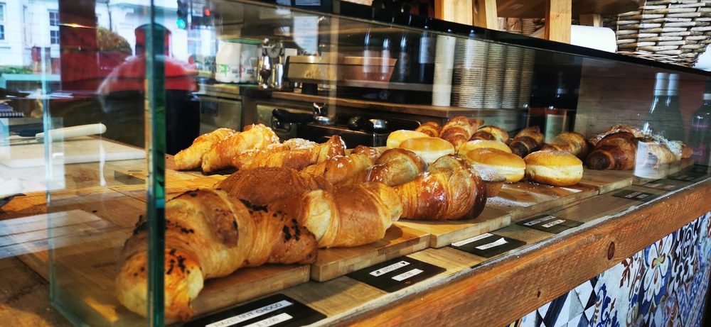 Croissants, cornetti and filled rolls in the glass display cabinet