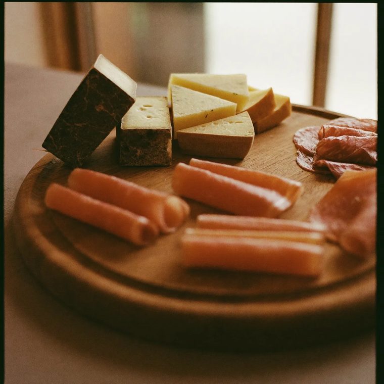 Sliced cured meats and cheese on a wooden board